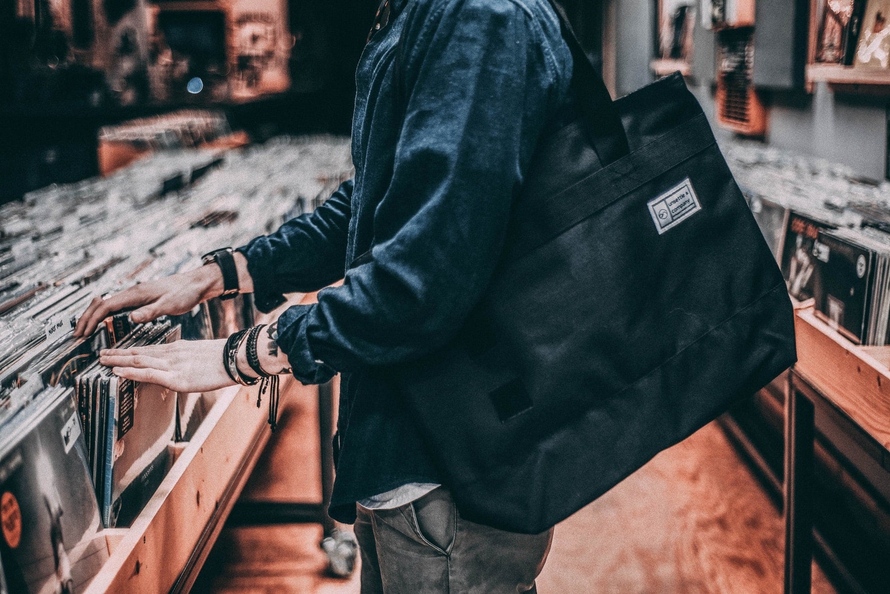 hipster-digging-through-vinyl-record-with-tote-bag